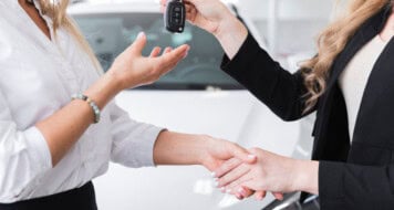 side view woman receiving car keys